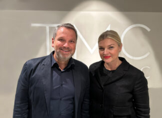 NOBILIS GROUP schließt Mehrheitserwerb an TMC Nordic erfolgreich ab Ein Mann und eine Frau, beide dunkel gekleidet, blicken in die Kamera. Im Hintergrund das TCM-Firmenlogo.