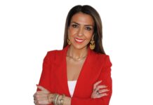 Angela Basile folgt bei E.A. Cosmetics auf Michael Betzelt Eine Frau mit langen Haaren in rotem Blazer und vor der Brust überkreuzten Armen blickt in die Kamera.