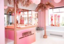 Deutschlands erstes DOUGLAS Café In Rosatönen gehaltene Verkaufsfläche mit goldenen Palmen.