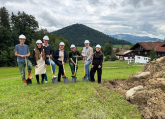 Haubers Naturresort erweitert Wellnessbereich Personengruppe mit Bauhelmen und Spaten neben einem großen Erdhaufen