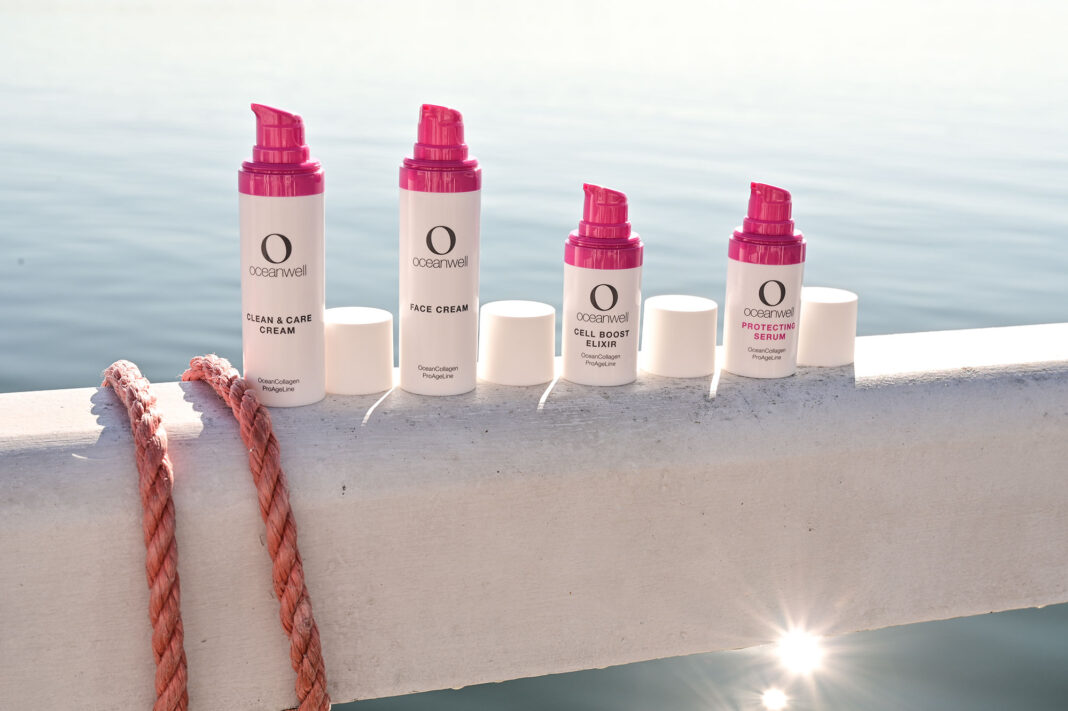 Oceanwell-Pflegeprodukte aufgereiht, mit Meer im Hintergrund