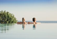 Verlosung: Wohlfühlzeit auf der Sonneninsel Usedom Eine Frau und ein Mann schauen vom Rand eines Infinity-Pools auf das Meer.