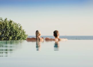 Verlosung: Wohlfühlzeit auf der Sonneninsel Usedom Eine Frau und ein Mann schauen vom Rand eines Infinity-Pools auf das Meer.
