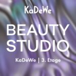 Kuratierte Erlebnis-Destination in Berlin Weißer Schriftzug KaDeWe Beauty Studio vor lia-grün gewirktem Hintergrund.