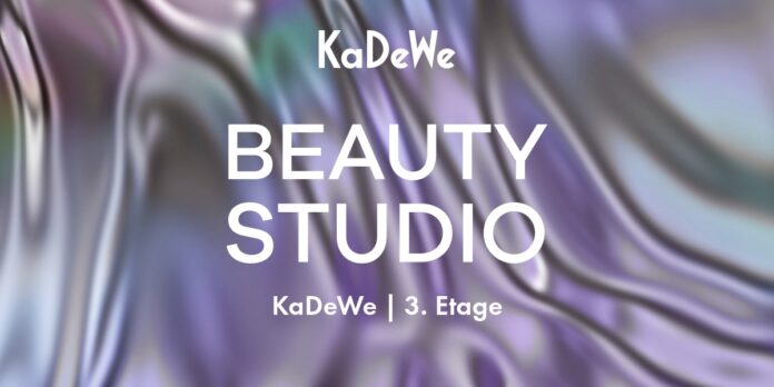 Weißer Schriftzug KaDeWe Beauty Studio vor lia-grün gewirktem Hintergrund.