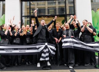Sephora eröffnet ersten eigenen Store in München Mitarbeitende von Sephora, alle dunkel gekleidet, stehen mit einem Banner vor dem Shop