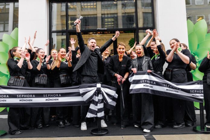 Mitarbeitende von Sephora, alle dunkel gekleidet, stehen mit einem Banner vor dem Shop