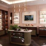 The House of Creed – Erste Flagship Boutique in Deutschland Ladengeschäft mit Einrichtung in dunkler Brauntönen, hellen Wänden. Auf dem Verkaufstresen und in den Regalen stehen bunte Flakons.