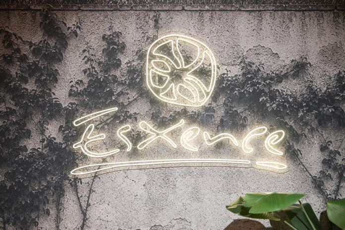 Schriftzug der Esxence vor einer grauen, bewachsenen Mauer