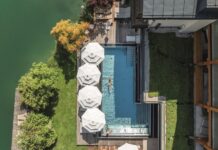 SPA inside verlost: Wohlfühlzeit am Wolfgangsee Blick von oben auf den Infinitiy-Pool mit Sonnenschirmen.