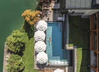 SPA inside verlost: Wohlfühlzeit am Wolfgangsee Blick von oben auf den Infinitiy-Pool mit Sonnenschirmen.