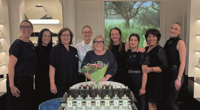 Eine Personengruppe von Frauen und einem Mann steht um eine Frau mit Blumenstrauß in der Hand