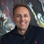 Marc vom Ende bei Bell Flavors & Fragrances in Leipzig Mann in Polo-Shirt vor buntem Gemälde