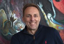 Marc vom Ende bei Bell Flavors & Fragrances in Leipzig Mann in Polo-Shirt vor buntem Gemälde