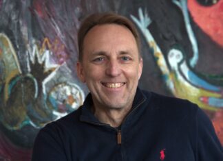 Marc vom Ende bei Bell Flavors & Fragrances in Leipzig Mann in Polo-Shirt vor buntem Gemälde